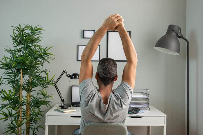 teletrabalho homem espriguicando